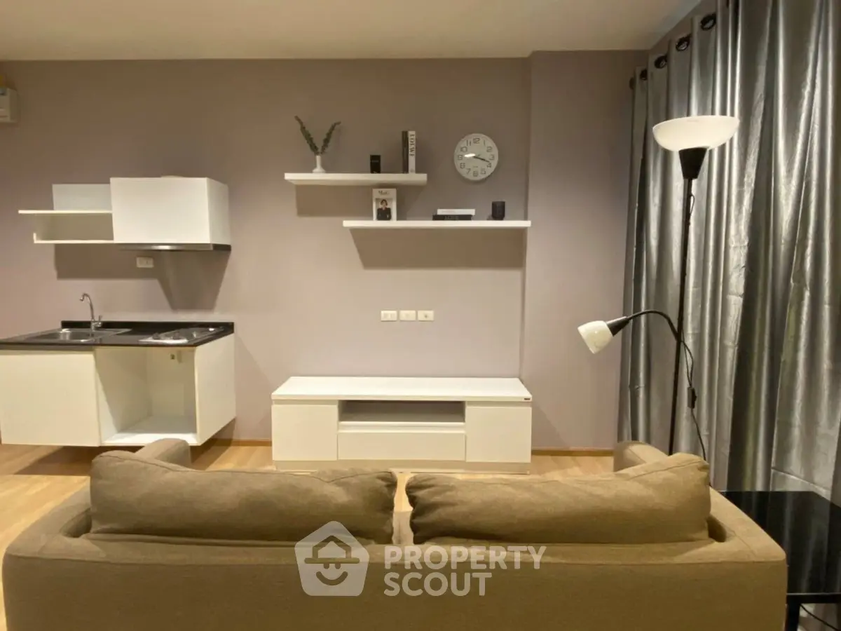 Modern living room with sleek furniture and open kitchen layout, perfect for contemporary urban living.