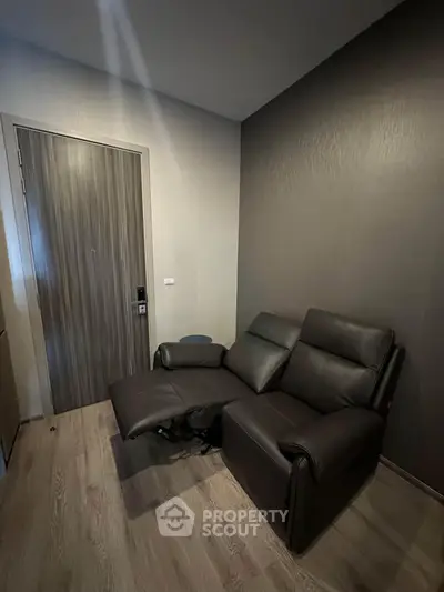 Cozy living room corner with modern recliner and stylish wooden flooring.