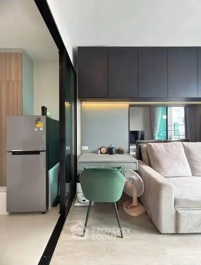 Modern living room with sleek furniture and integrated kitchen area, featuring a cozy sofa and stylish decor.