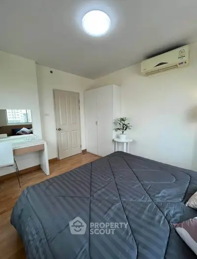 Cozy bedroom with modern decor and air conditioning, featuring a comfortable bed and stylish furniture.