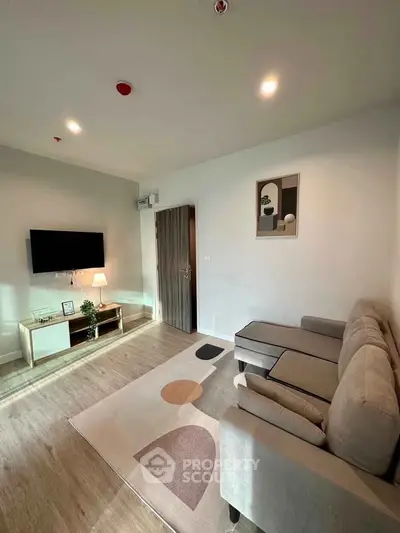 Modern living room with cozy sofa and wall-mounted TV in stylish apartment.
