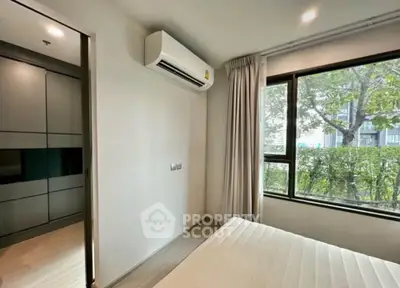 Modern bedroom with large window and air conditioning in a stylish apartment.