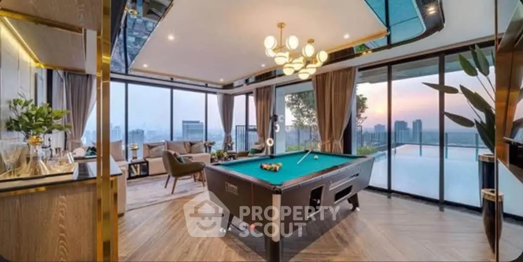 Luxurious penthouse with pool table and stunning city skyline view at sunset.