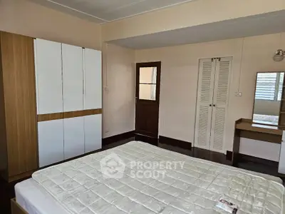 Spacious bedroom with modern wardrobe and cozy bed in a stylish apartment.