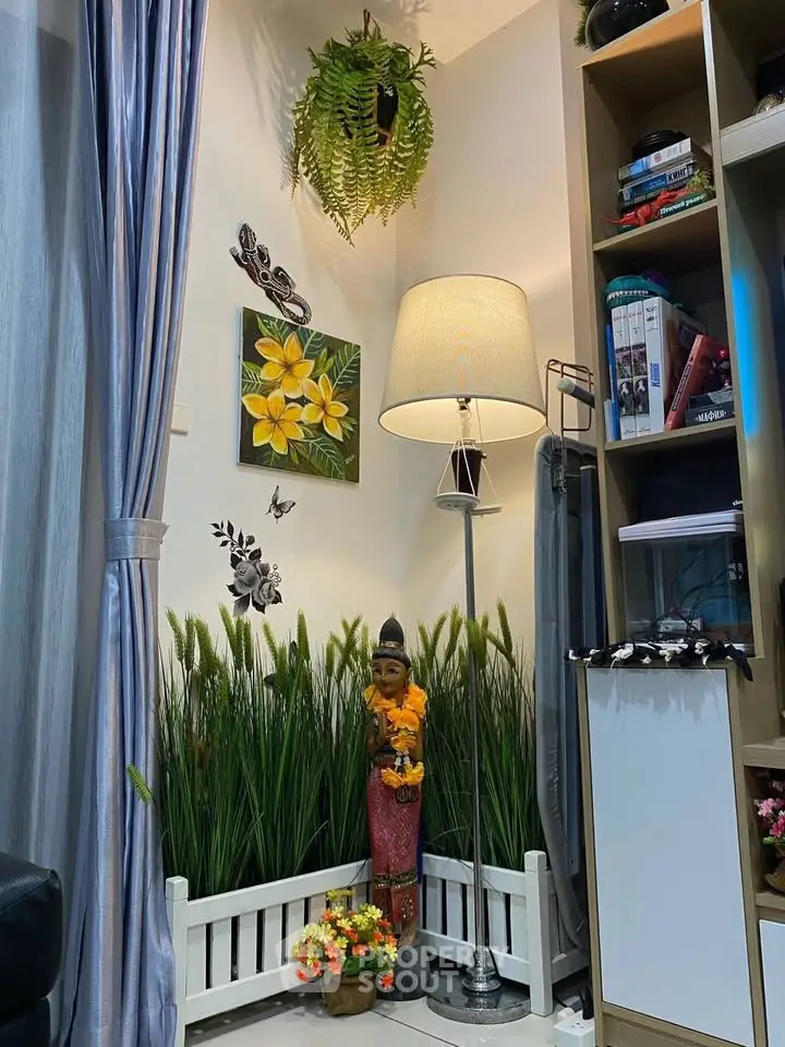 Cozy living room corner with decorative plants, floor lamp, and bookshelf.