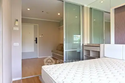 Modern bedroom with sliding glass doors and hardwood flooring in a stylish apartment.