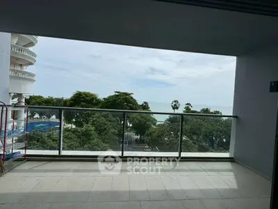 Spacious balcony with stunning ocean view and lush greenery.
