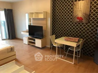 Modern living room with stylish decor and open layout, featuring a TV and dining area.