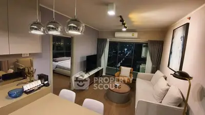 Modern living room with open layout and city view, featuring stylish furniture and ambient lighting.