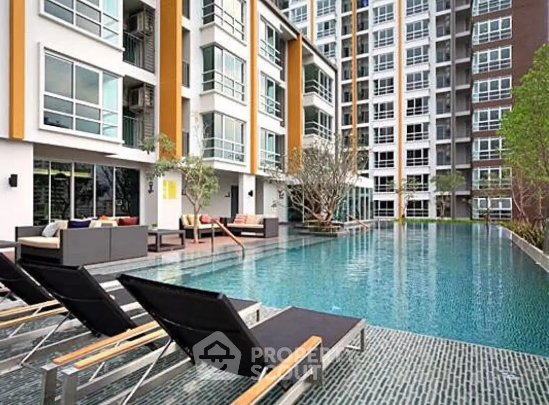 Modern apartment complex with luxurious pool and stylish outdoor seating.
