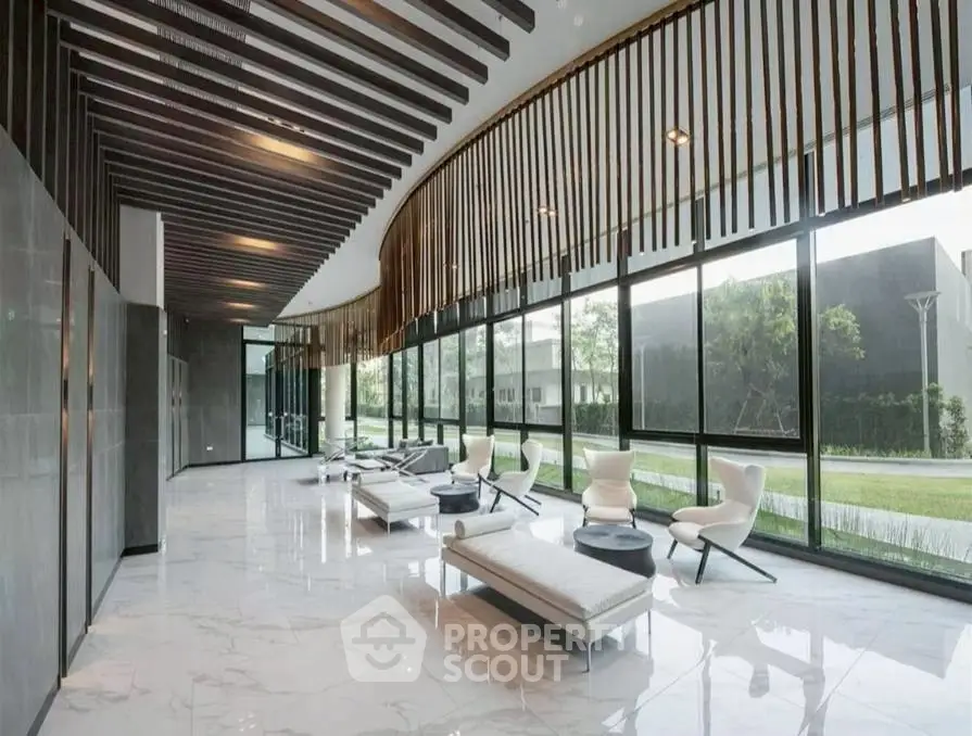 Luxurious modern lobby with sleek design and floor-to-ceiling windows offering stunning garden views.