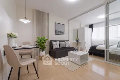 Modern open-plan living room with dining area and cozy bedroom.