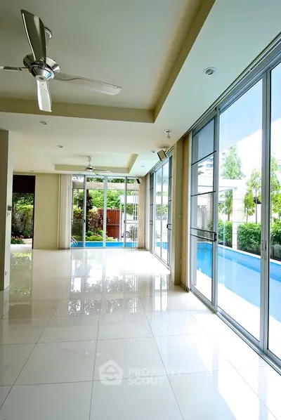 Spacious modern living room with pool view and large windows
