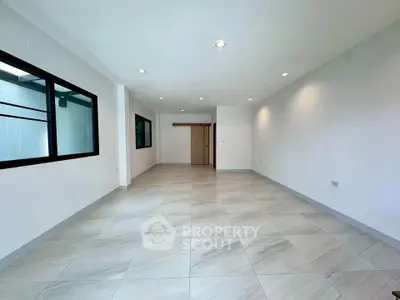 Spacious modern living room with sleek tile flooring and recessed lighting