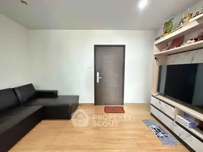 Modern living room with sleek black sofa and large TV unit, perfect for cozy family gatherings.
