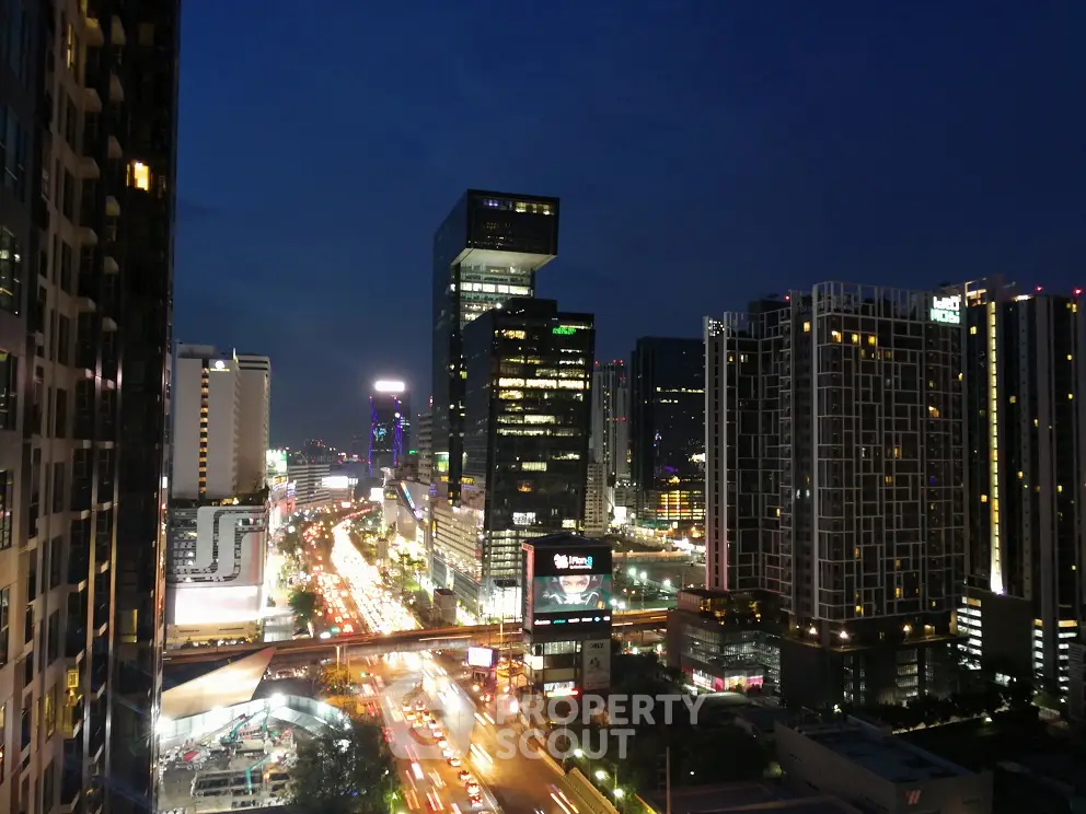 Stunning cityscape view of modern high-rise buildings at night with vibrant city lights.