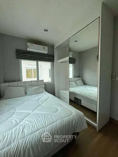 Cozy modern bedroom with mirrored wardrobe and natural light