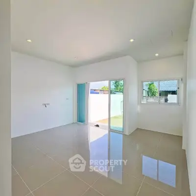Spacious modern living room with glossy tiled floors and large windows for natural light.