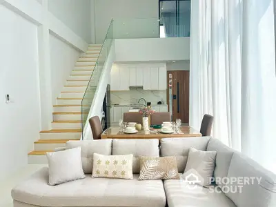 Modern duplex living room with elegant dining area and stylish staircase