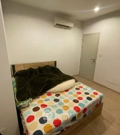 Cozy bedroom with colorful bedding and modern air conditioning unit