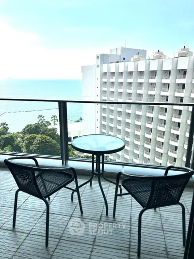 Stunning balcony view with ocean backdrop and modern seating, perfect for relaxation.