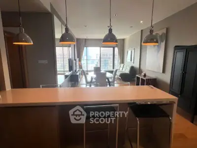 Modern open-plan living room with stylish lighting and city view.