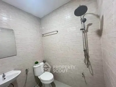 Modern bathroom with sleek showerhead and minimalist design, perfect for contemporary living.