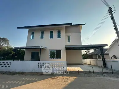 Modern two-story house with spacious driveway and minimalist design in a serene neighborhood.