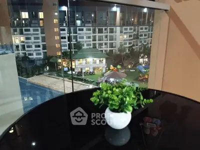 Stunning view from balcony overlooking pool and garden area at night.