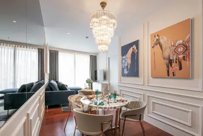 Luxurious living room with elegant chandelier and horse-themed artwork, perfect for stylish urban living.