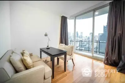 Bright and inviting living room with large windows offering a stunning city view, complemented by sleek hardwood floors and modern furnishings.