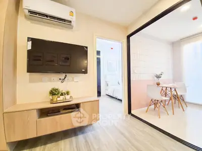 Modern living room with wall-mounted TV and dining area in open layout apartment