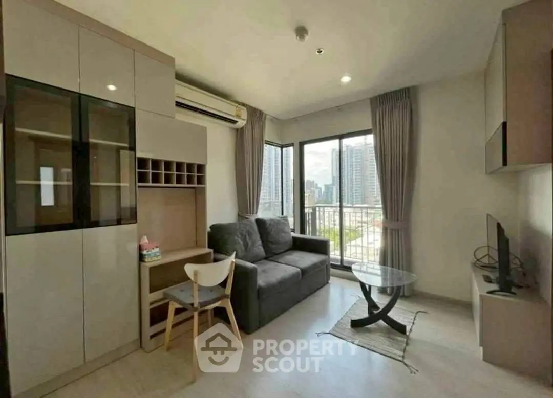 Modern living room with city view, featuring cozy sofa and sleek furniture.