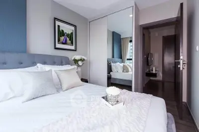 Elegant bedroom with modern decor and mirrored wardrobe in a stylish apartment.