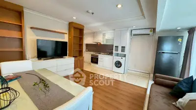 Modern open-layout living room with kitchen, featuring TV, washing machine, and fridge.