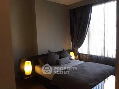 Cozy bedroom with modern decor and soft lighting, featuring a large window with elegant curtains.