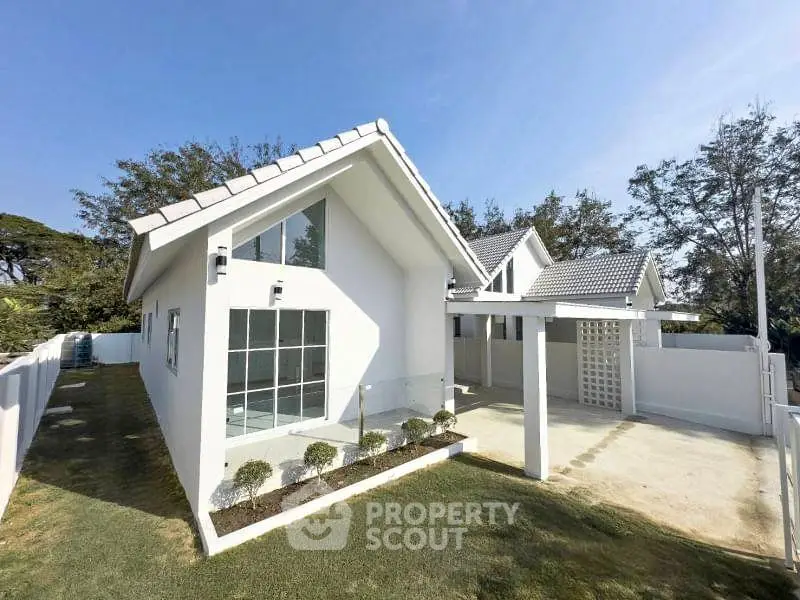 Charming modern white house with spacious driveway and lush greenery