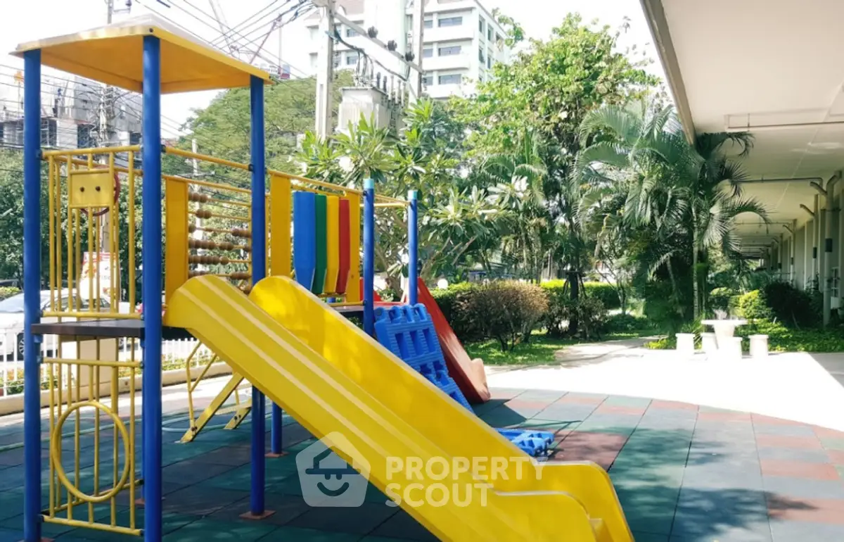 Vibrant playground area in a residential complex with lush greenery and modern amenities.