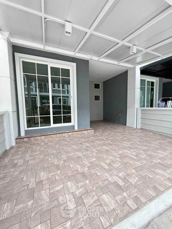 Spacious modern entrance with elegant tiled flooring and large glass doors.