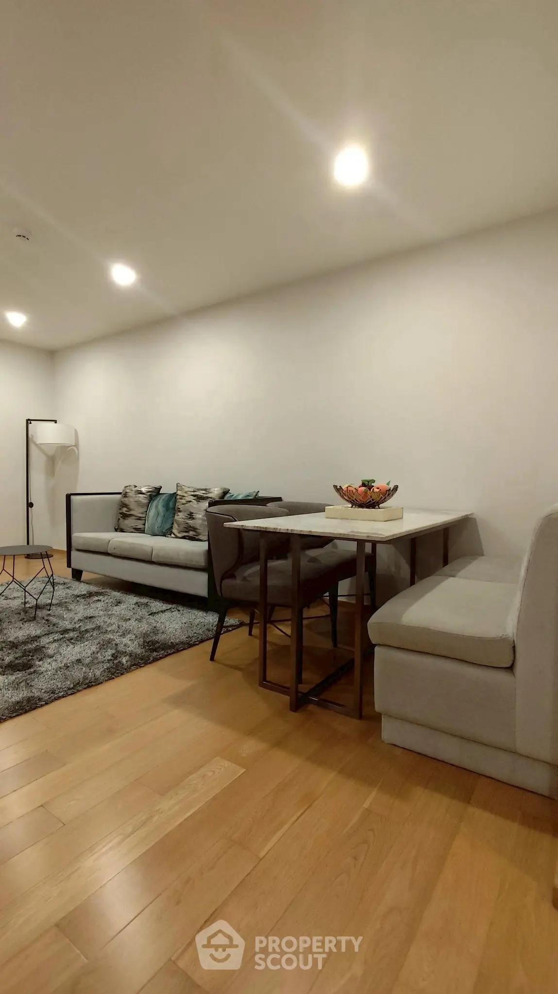 Modern living room with cozy seating and dining area, featuring stylish decor and warm lighting.