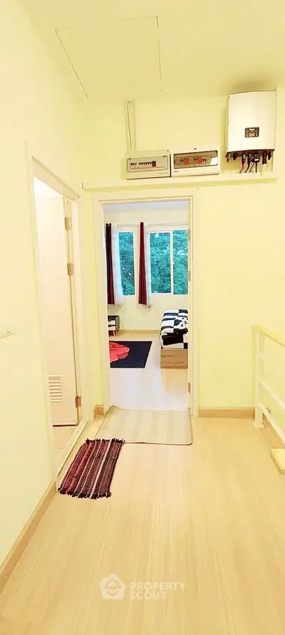 Bright hallway leading to a cozy living room with large windows and scenic view.