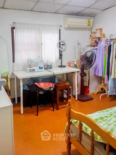 Cozy bedroom with sewing station and air conditioning, perfect for creative living.