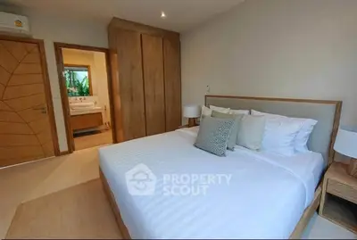 Spacious bedroom with ensuite bathroom and modern wooden furniture