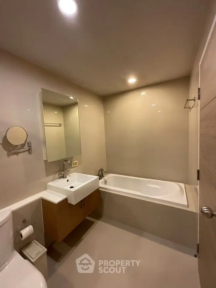 Modern bathroom with sleek fixtures and bathtub in a contemporary apartment.