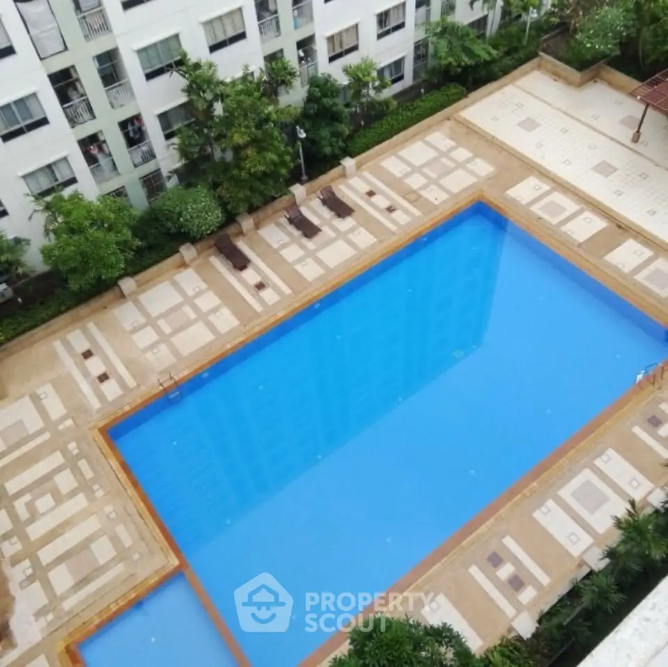 Luxurious apartment complex with stunning outdoor pool and lush greenery