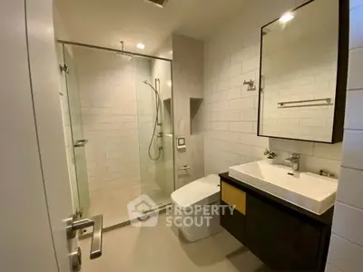 Modern bathroom with glass shower and sleek fixtures in a contemporary apartment.