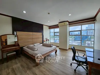 Spacious bedroom with city view, wooden furniture, and modern decor