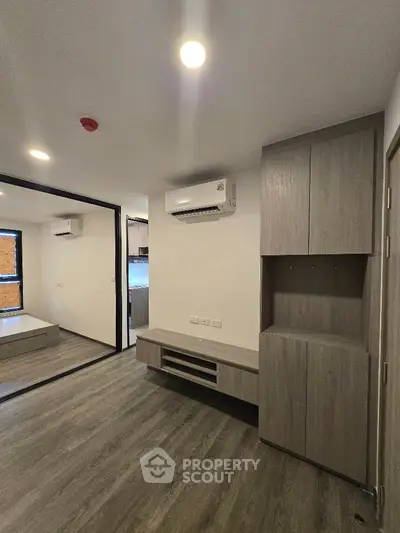 Modern apartment interior with sleek wooden flooring and built-in storage solutions.