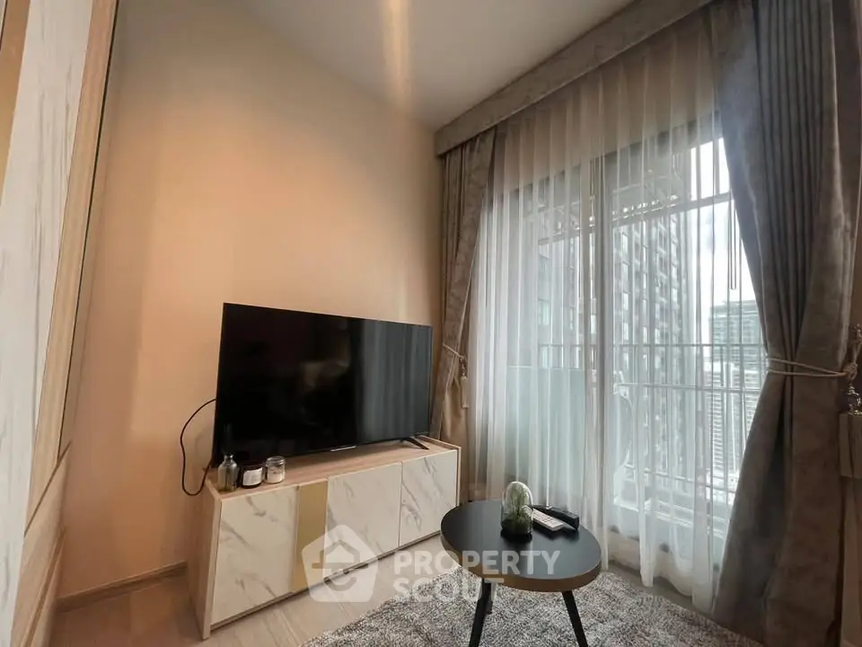 Modern living room with large TV and elegant curtains, featuring a cozy atmosphere and natural light.