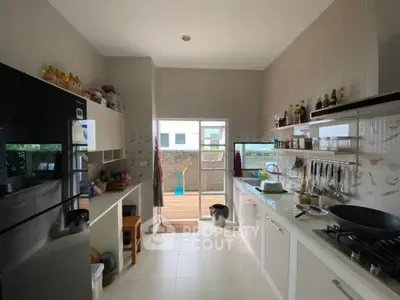 Modern kitchen with open layout and gas stove, featuring sleek appliances and ample natural light.